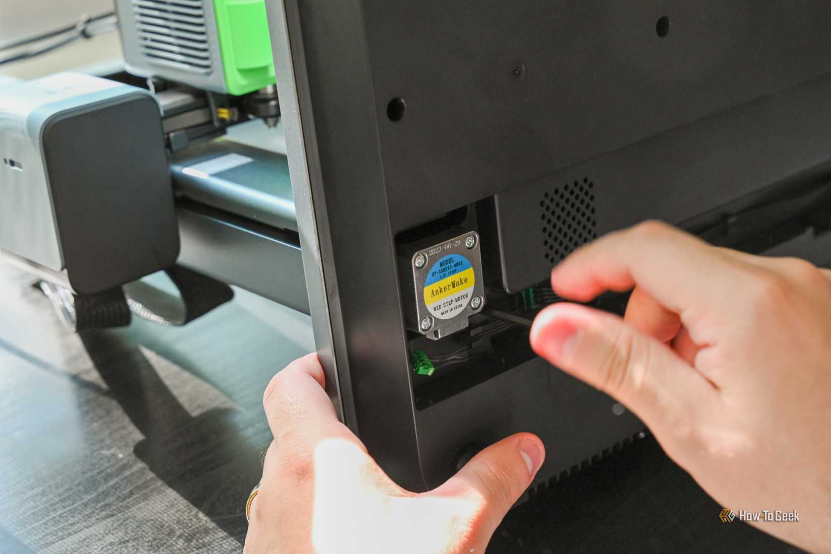 Person assembling the AnkerMake M5C 3D Printer