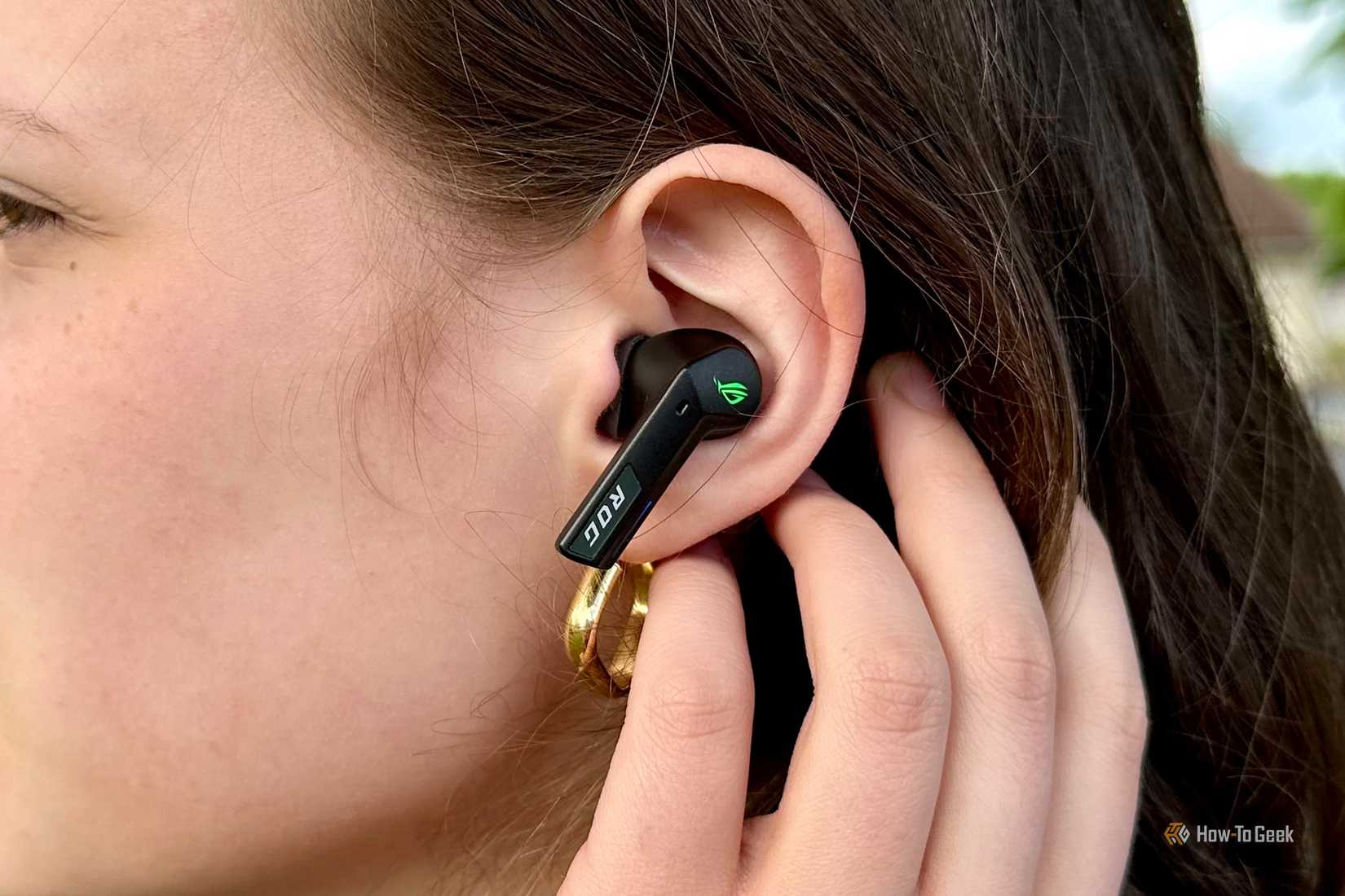 Side profile of woman wearing ROG Cetra True Wireless SpeedNova Headphones.