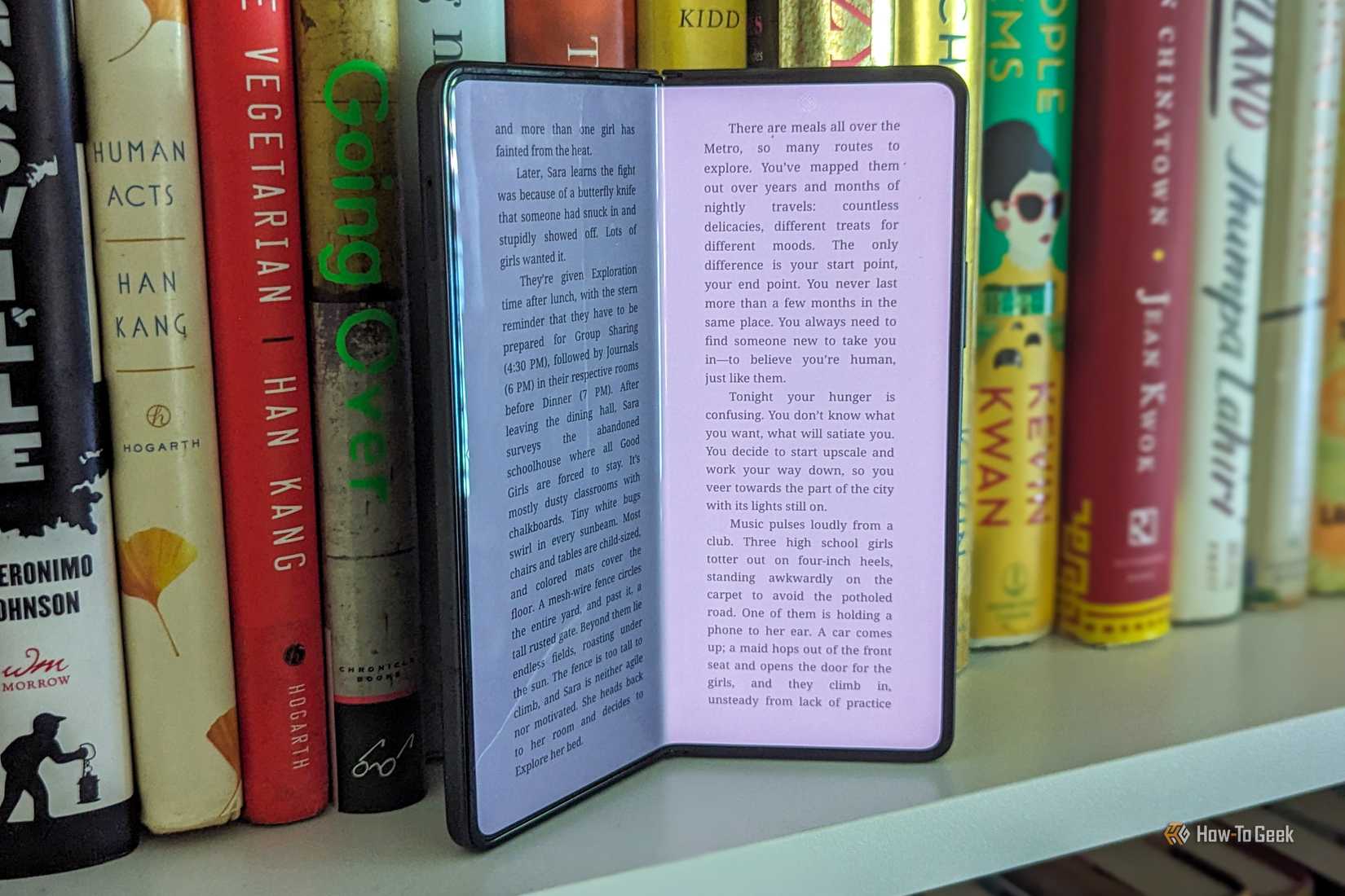 Um Samsung Galaxy Z Fold 5 ligeiramente aberto numa estante.