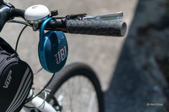 The JBL Clip 5 attached to a bike's handlebars. 