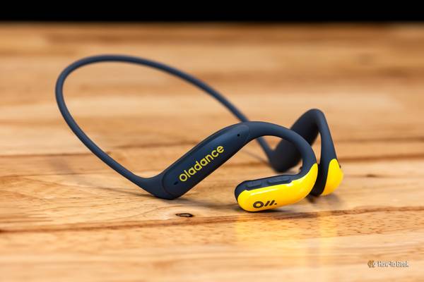 A pair of Oladance OWS Sports headphones on a wood table