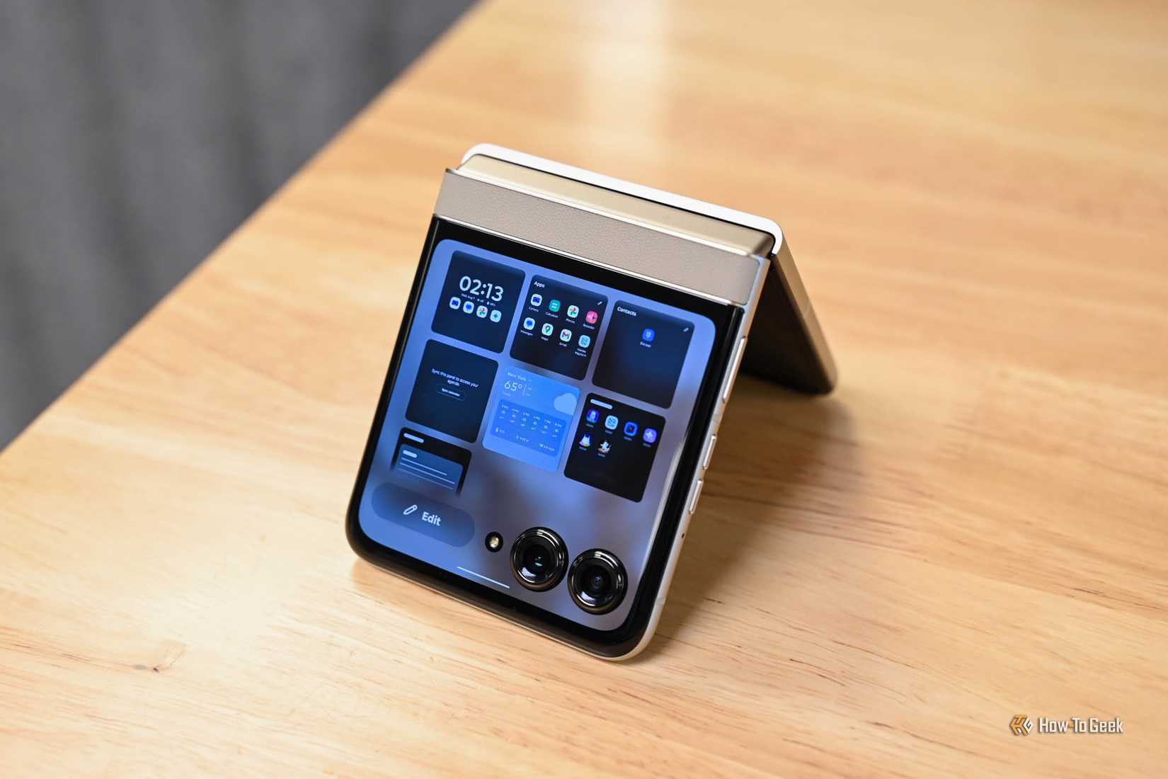 Motorola Razr стоит на деревянном столе, сложен «домиком».