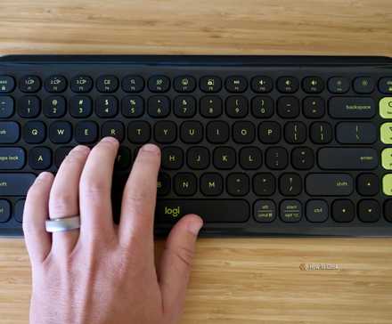 机の上にあるロジクール ポップ アイコン キーとその上でタイピングする手。