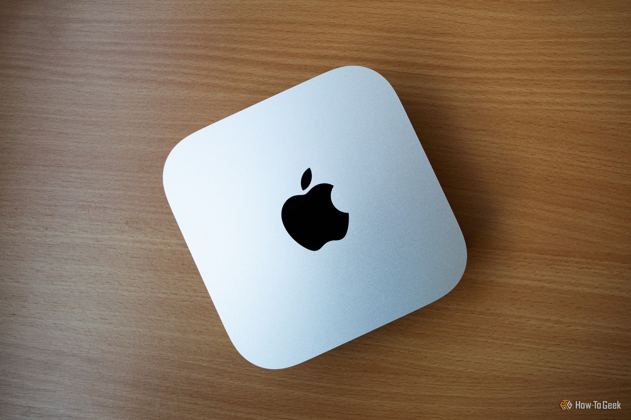 an M4 Mac Mini sitting on a wooden table. 