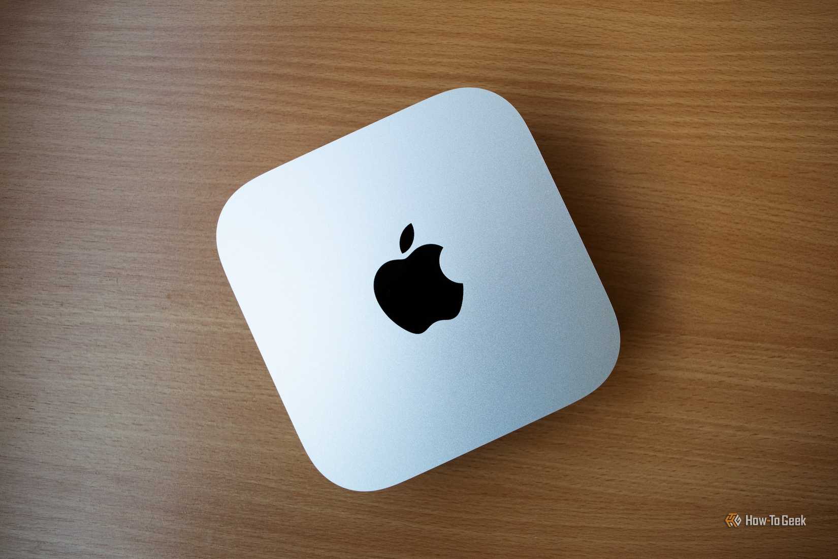a Mac Mini M4 sitting on a wooden table. 
