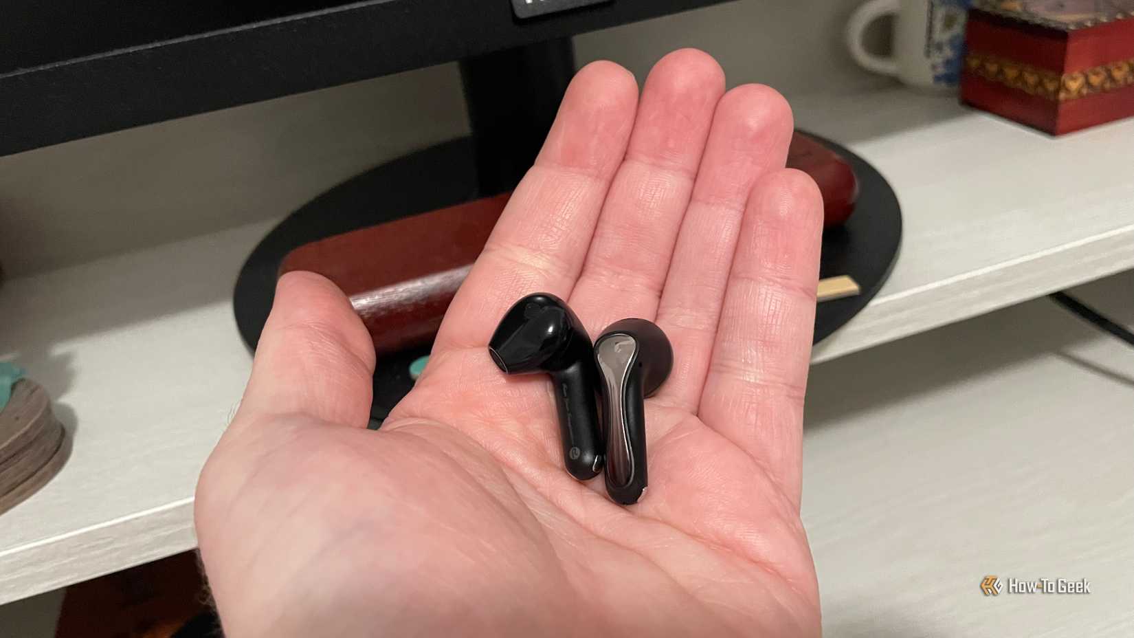 A person holding the SoundPEATS Air5 Wireless Earbuds.