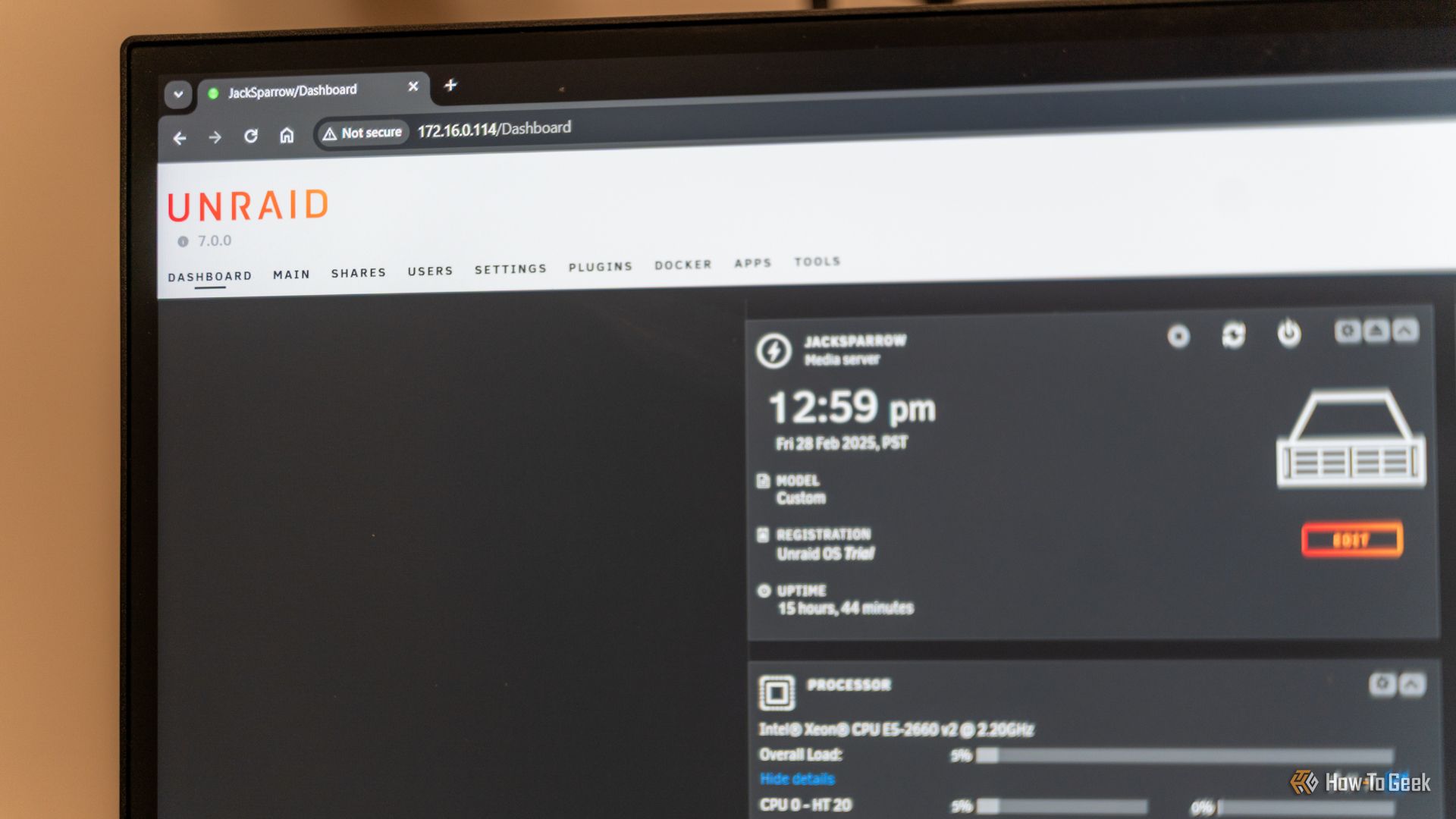 The Unraid dashboard opened on a computer monitor showing the logo and some server statistics.