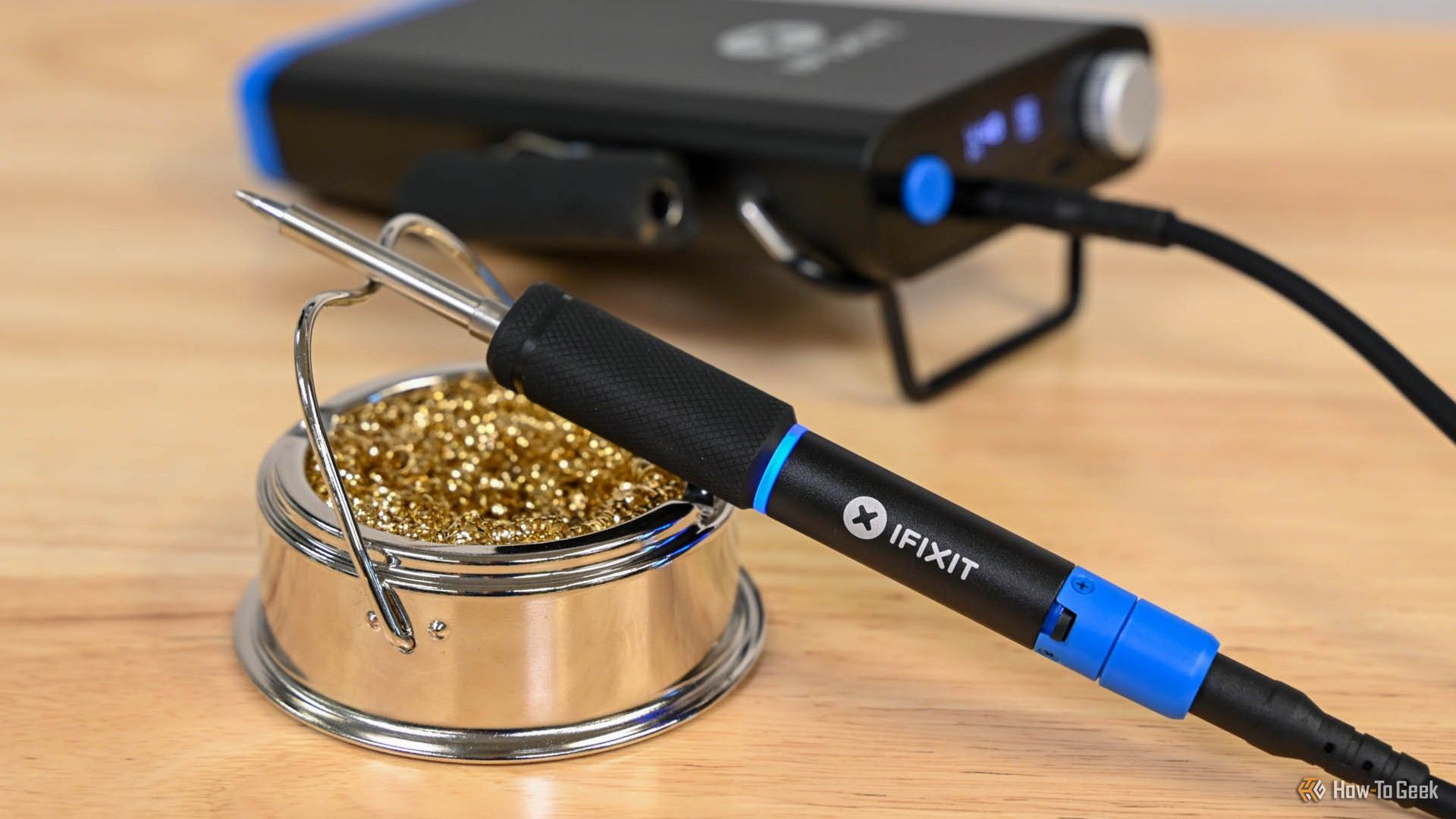 The iFixit FixHub Portable Soldering Iron on a cleaner stand.