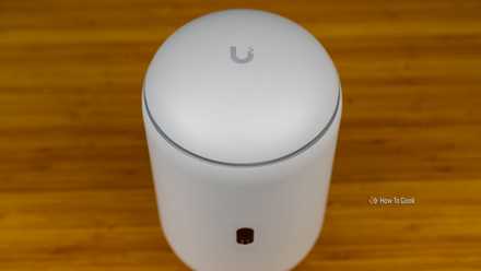 A top-down view of the Unifi Dream Router 7 with the Unifi logo visible.