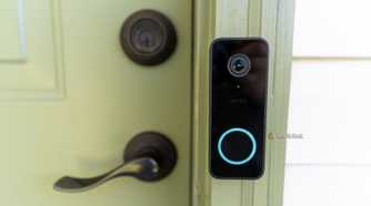 The Wyze Video Doorbell V2 mounted to a green front door.