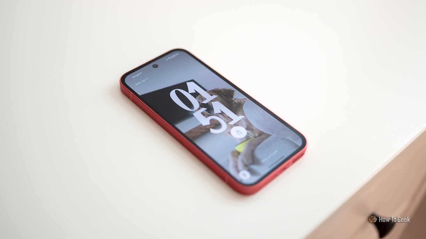 Google Pixel 9a laying on a table showing the lock screen.