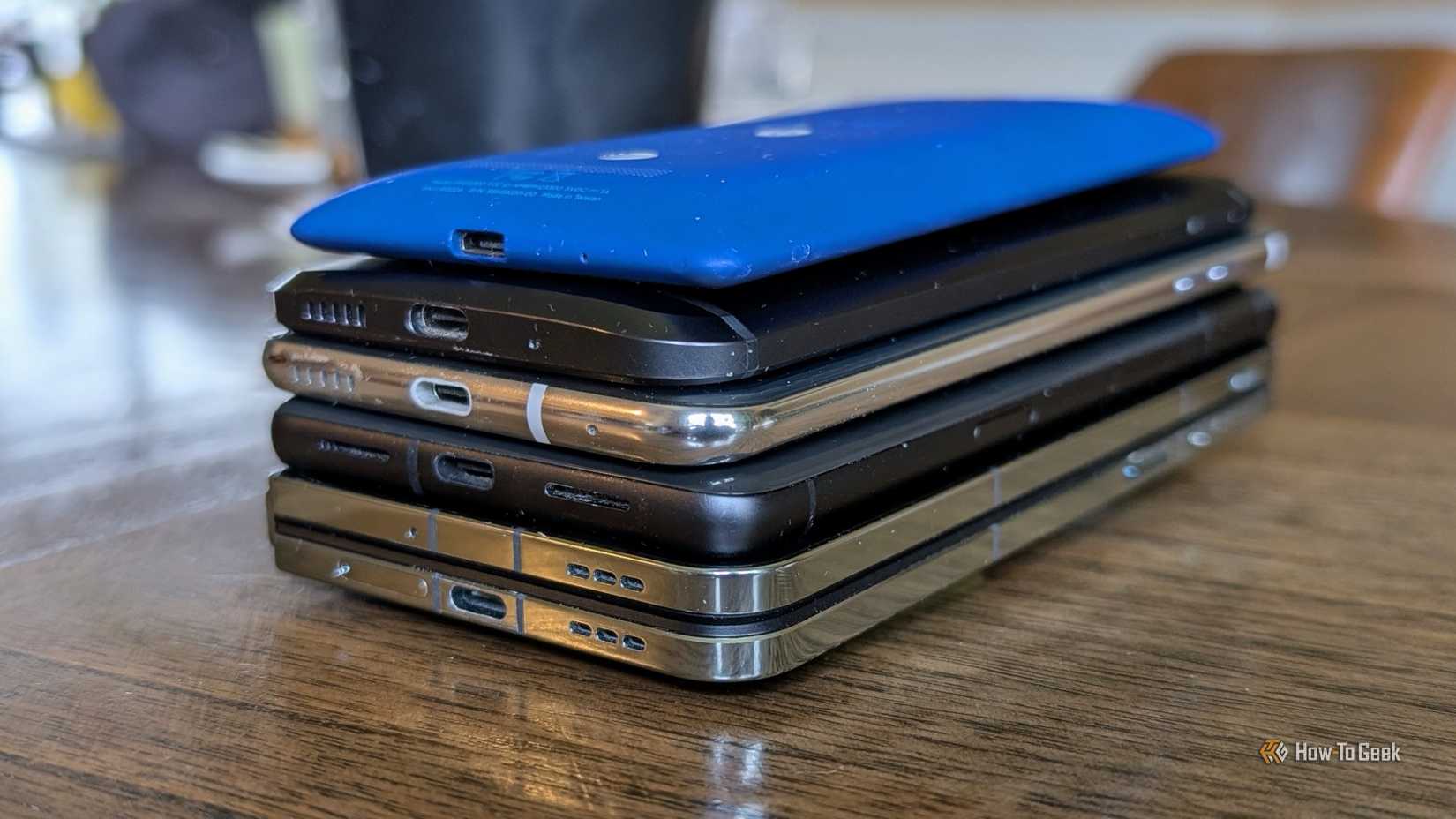 A stack of five smartphones.