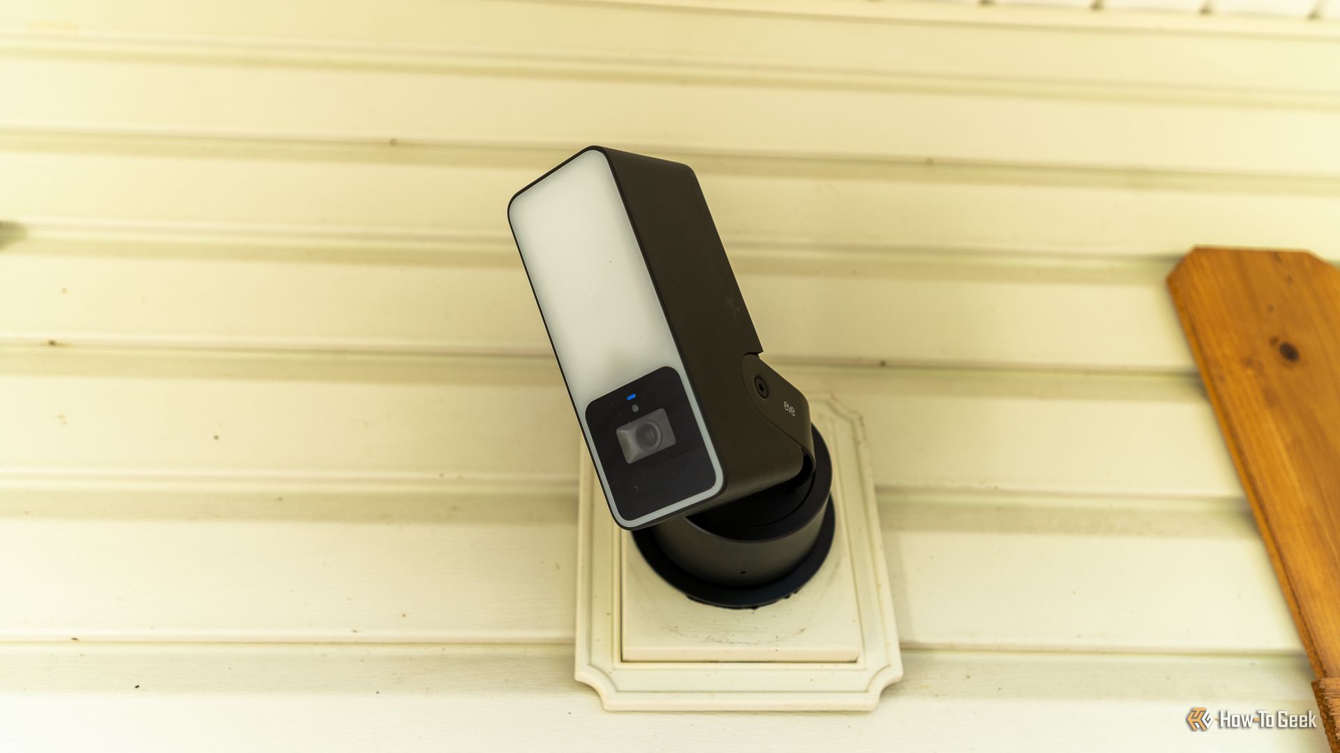 The front of the Eve Outdoor Cam mounted to a wall.