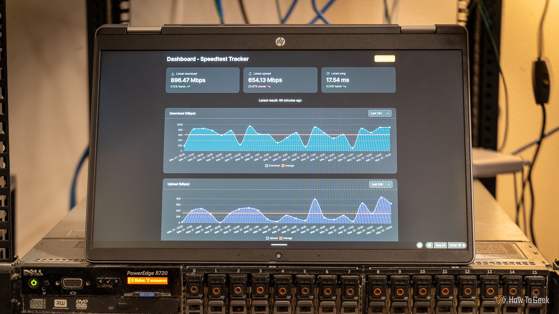 A laptop showing the Speedtest-Tracker Docker container sitting on top of a server.