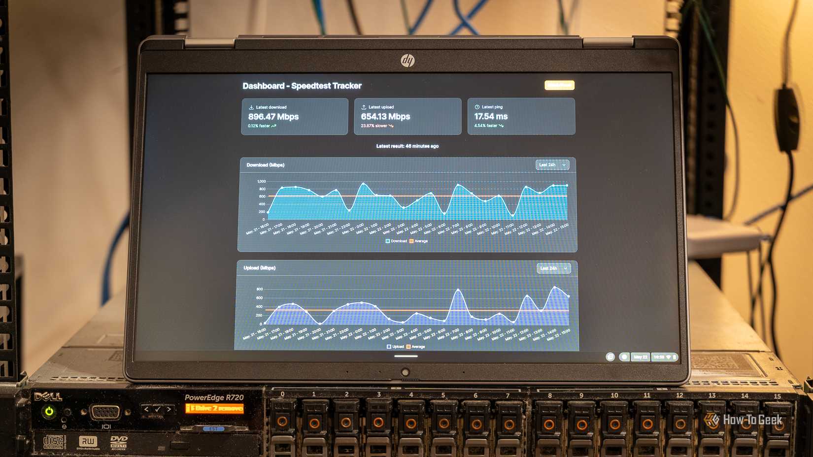 A laptop showing the Speedtest-Tracker Docker container sitting on top of a server.
