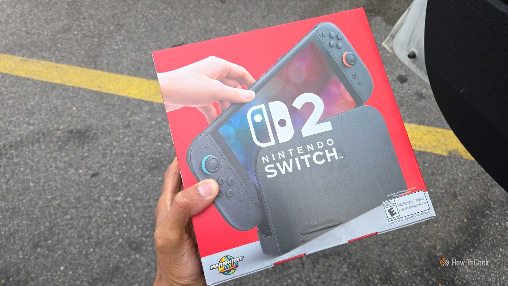 A hand holding the box of a Nintendo Switch 2.