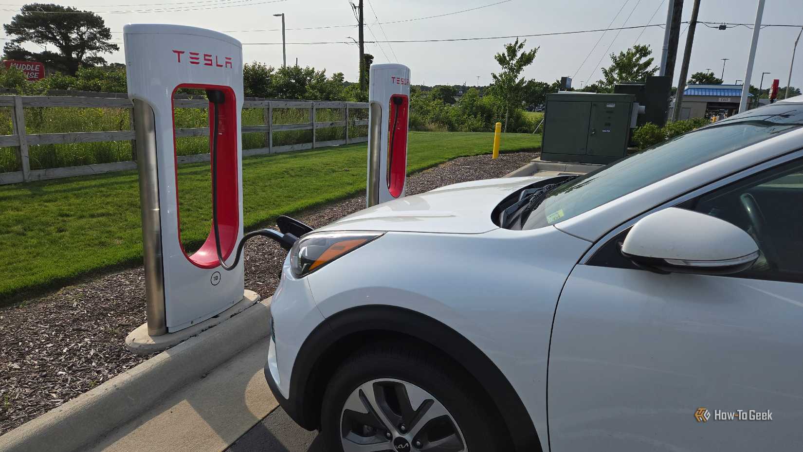 Kia Niro EV заряжается на станции Tesla Supercharger.