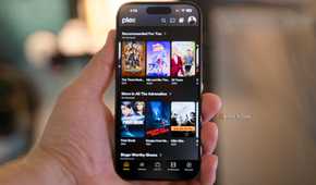 An iPhone 15 Pro in hand showing the Plex recommendations interface.
