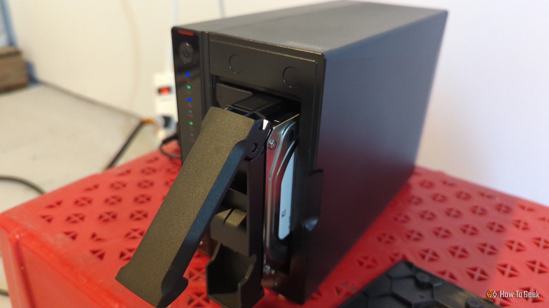 An Asustor NAS with one hard drive pulled partially out of the bay.