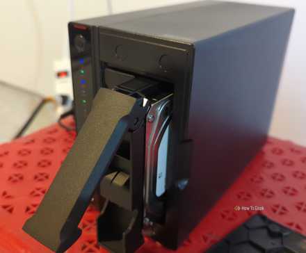 An Asustor NAS with one hard drive pulled partially out of the bay.