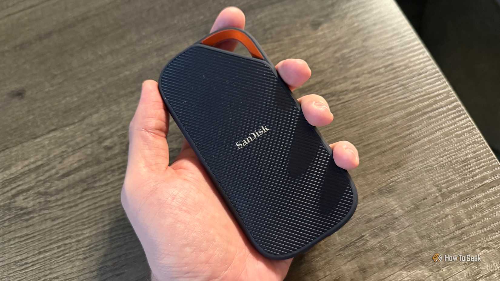One hand holds the SanDisk Extreme PRO portable SSD with USB4.