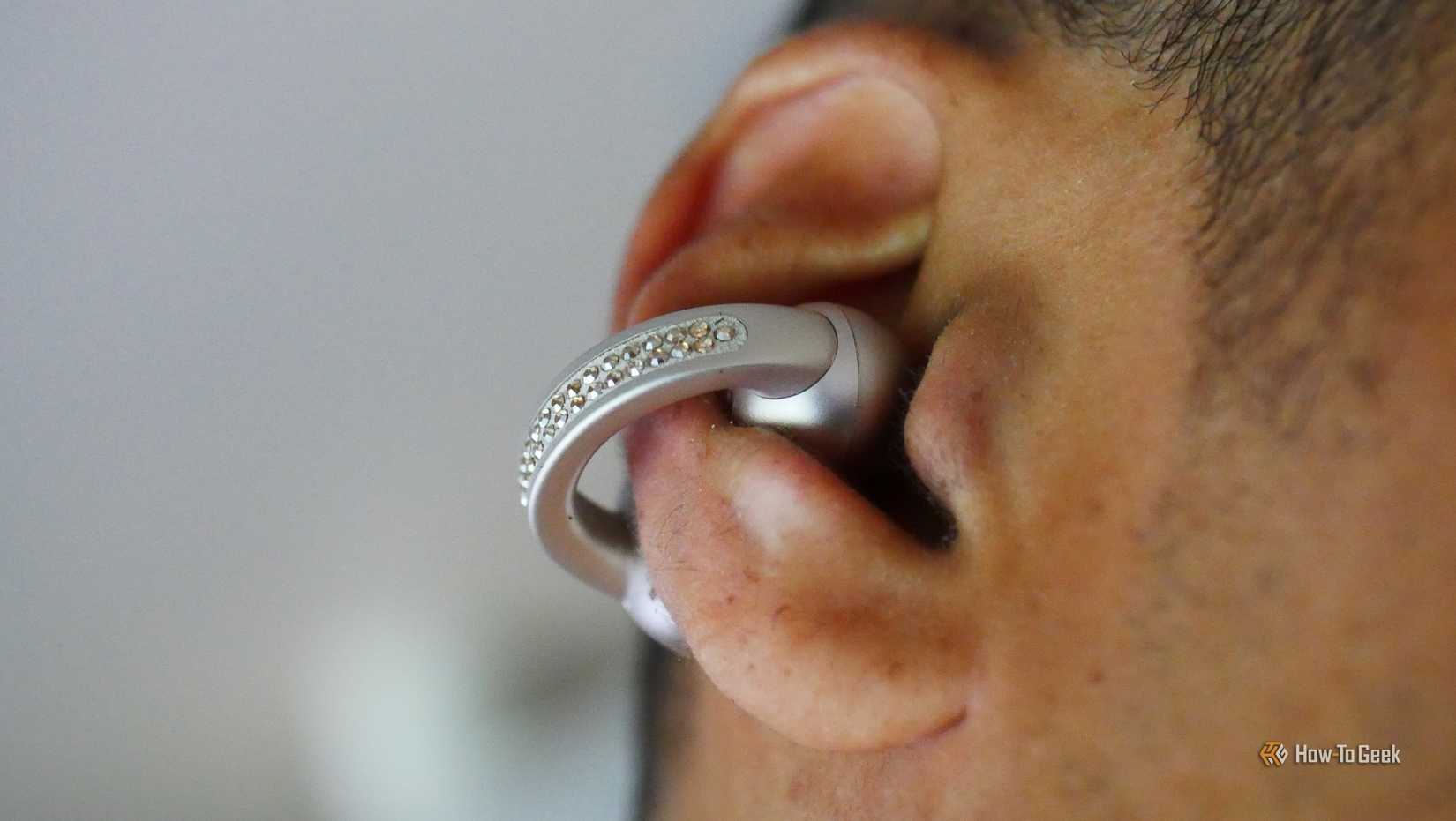 A ear wearing a Moto Buds Loop earbud.