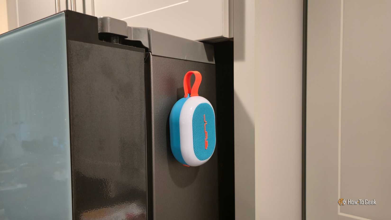 A JLab Pop Party speaker magnetically attached to a fridge