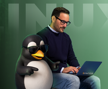 A man using a laptop next to Tux, the Linux mascot wearing sunglasses.