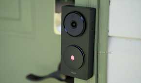 A side view of Aqara's Doorbell Camera Hub G410 mounted to a green door frame.