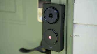 A side view of Aqara's Doorbell Camera Hub G410 mounted to a green door frame.