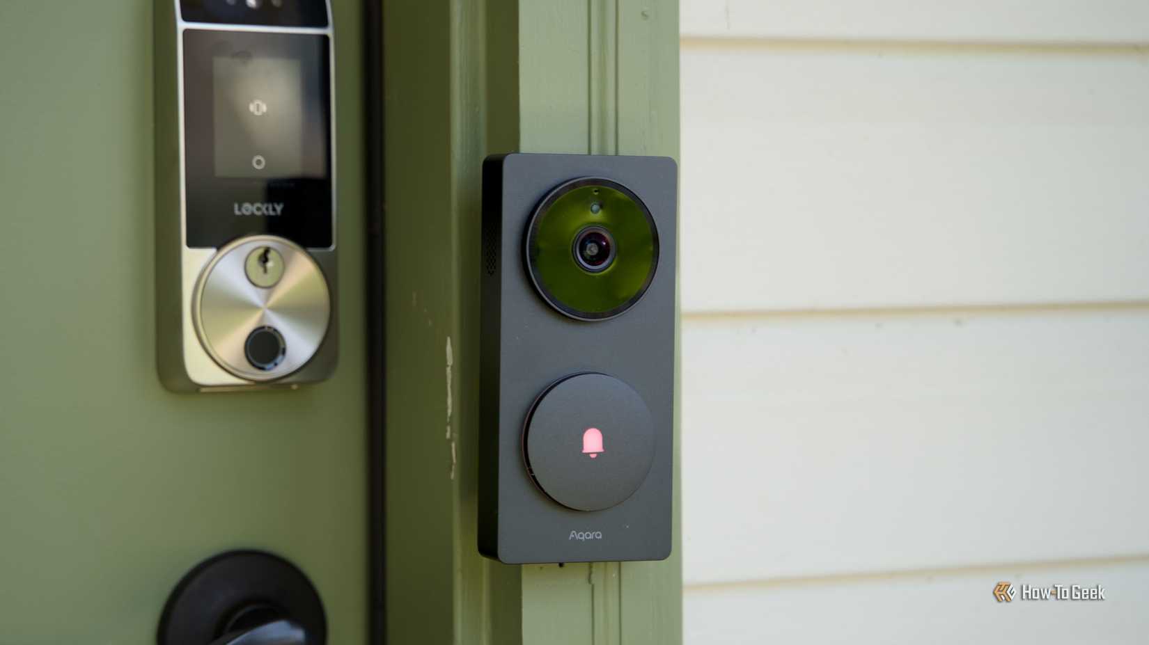 The Aqara Doorbell Hub G410 from the side mounted to a green door frame with a Lockly smart lock in the background.