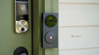 The Aqara Doorbell Hub G410 from the side mounted to a green door frame with a Lockly smart lock in the background.