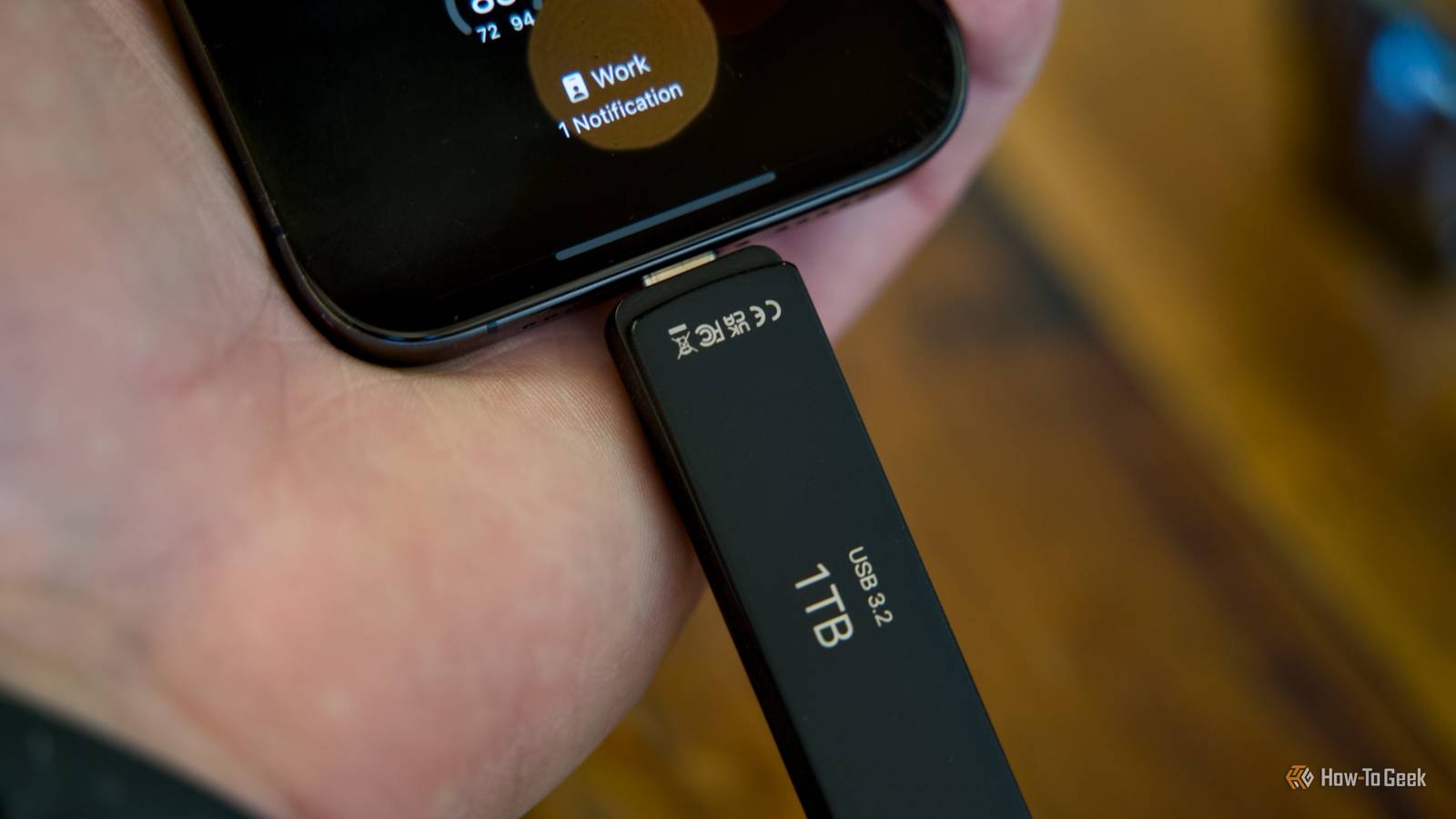 The PNY Duo Link V3 flash drive plugged into the bottom of an iPhone 15 Pro.