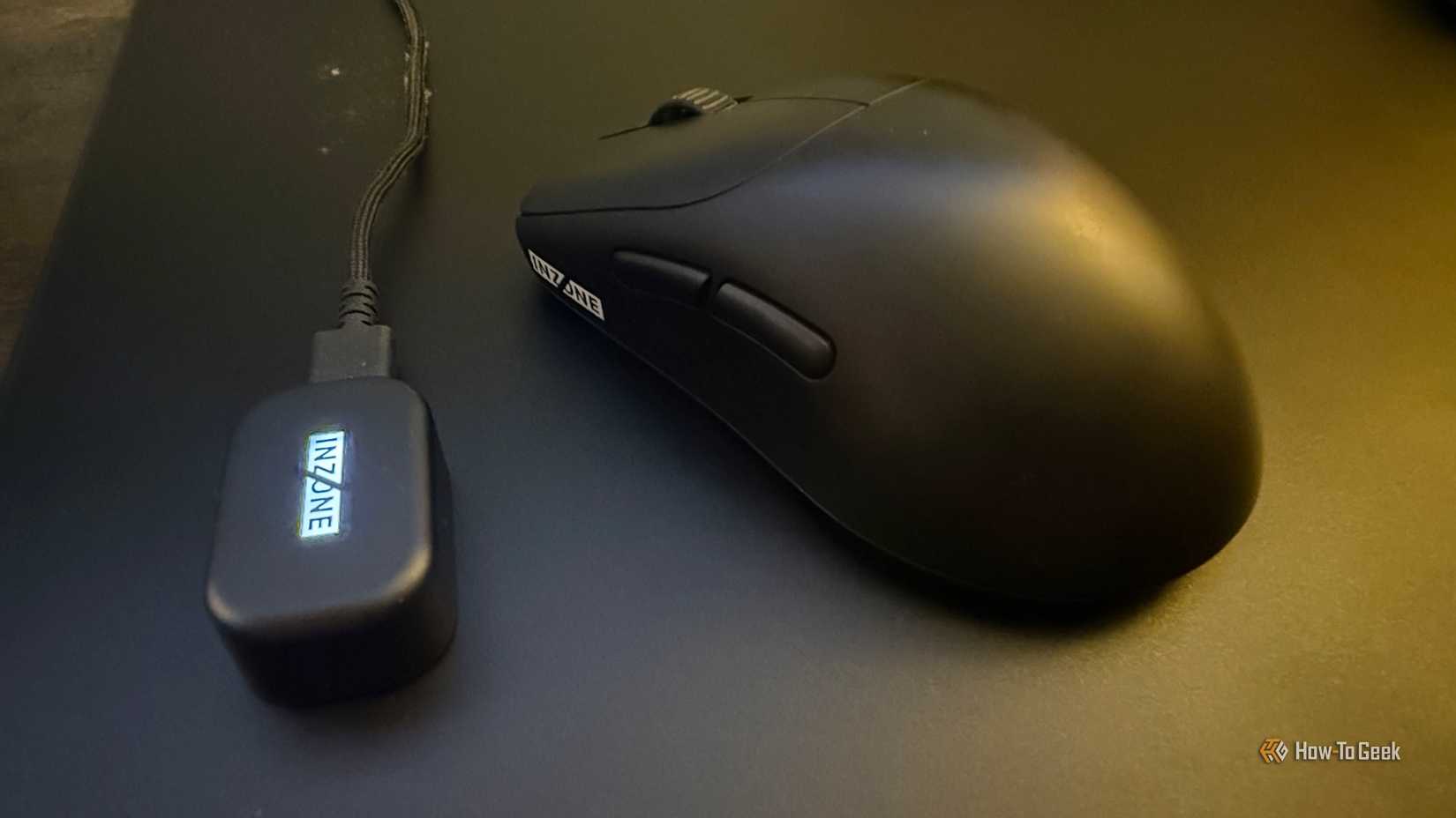 The Sony INZONE Mouse-A and its lit-up wireless dongle on a glass mousepad.