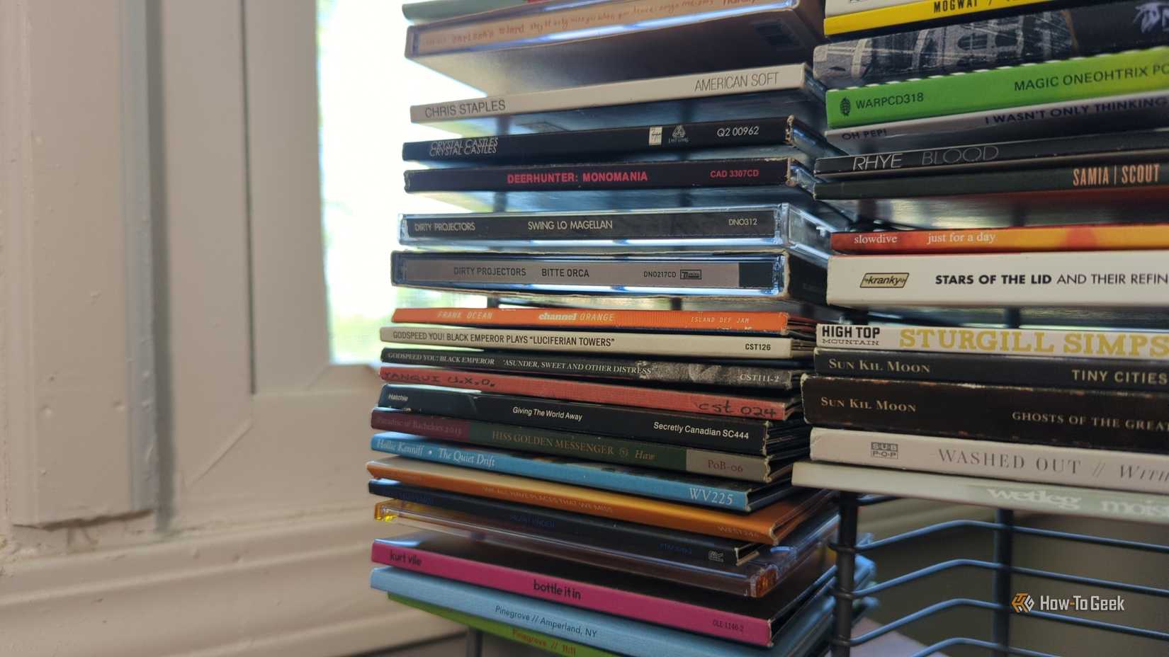 Several albums on a wire rack CD holder.