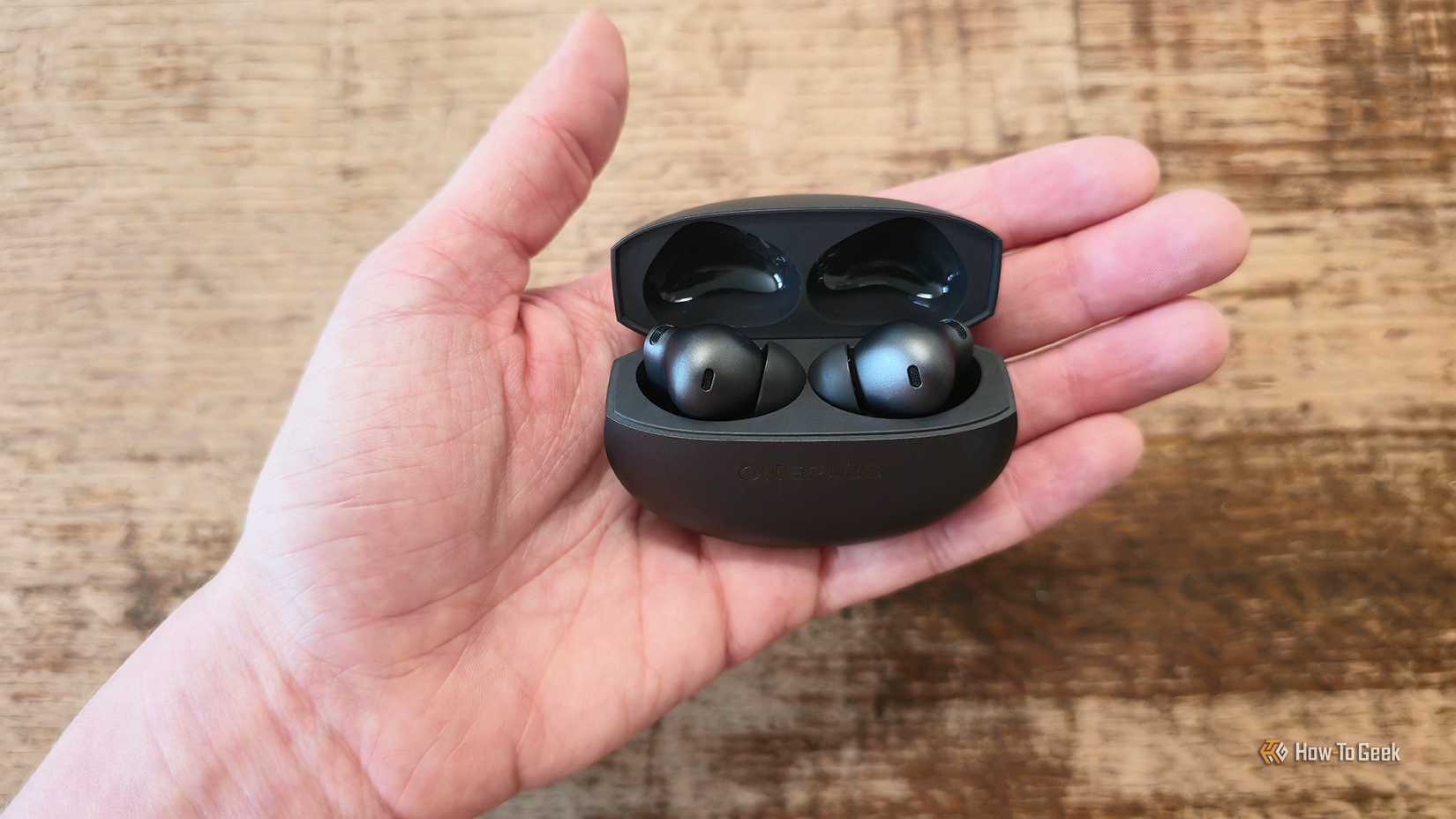 Someone holding the OnePlus Buds 4 charging case.