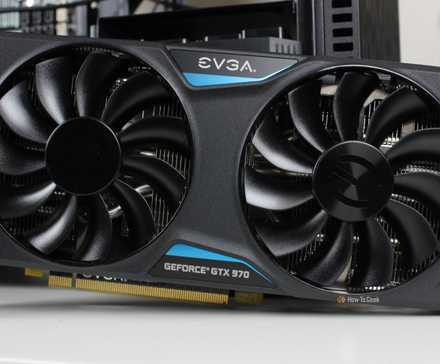 The EVGA NVIDIA GeForce GTX 970 SSC GAMING ACX 2.0 graphics card sitting on a desk.