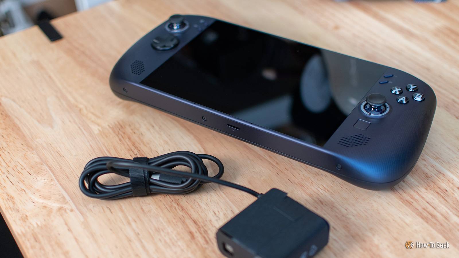 The Lenovo Legion Go S sitting on a table with its power adapter.