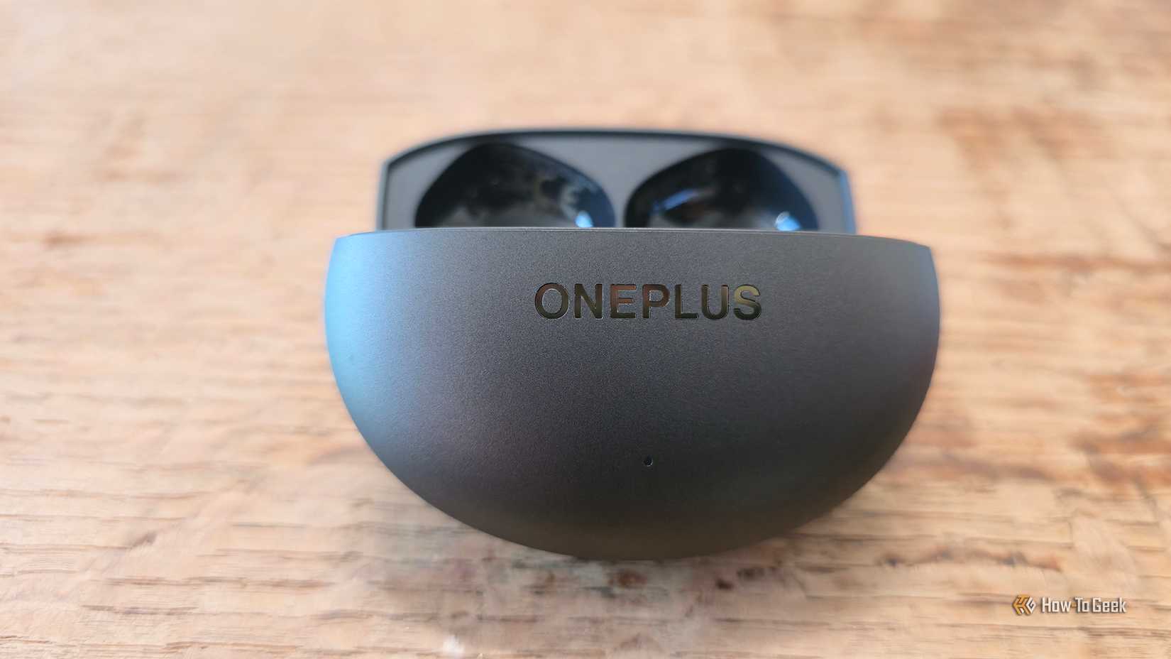The OnePlus Buds 4 charging case sitting open on a table.