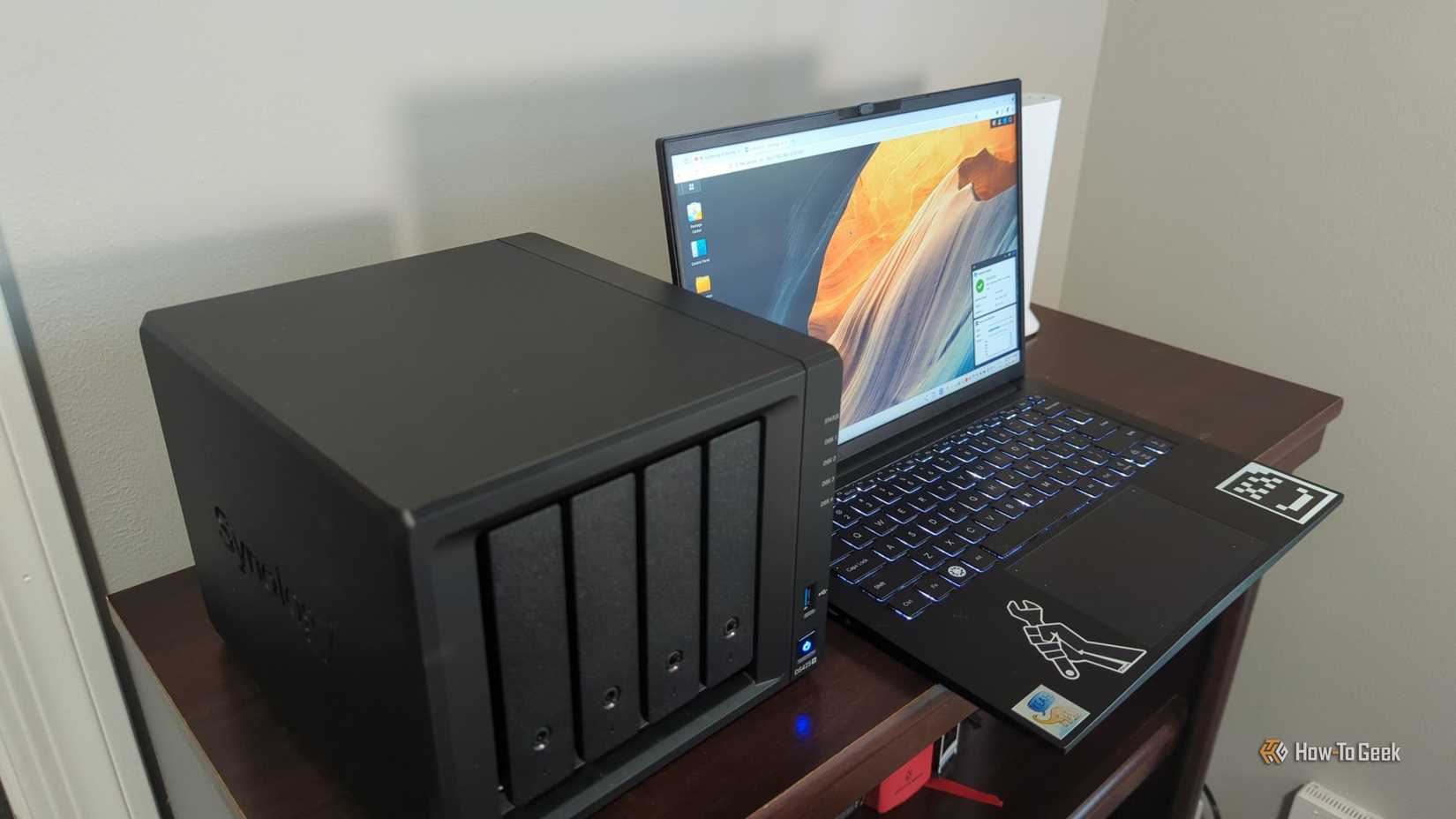 The Synology DS425+ NAS next to a laptop comupter showing the DSM operating system.-2