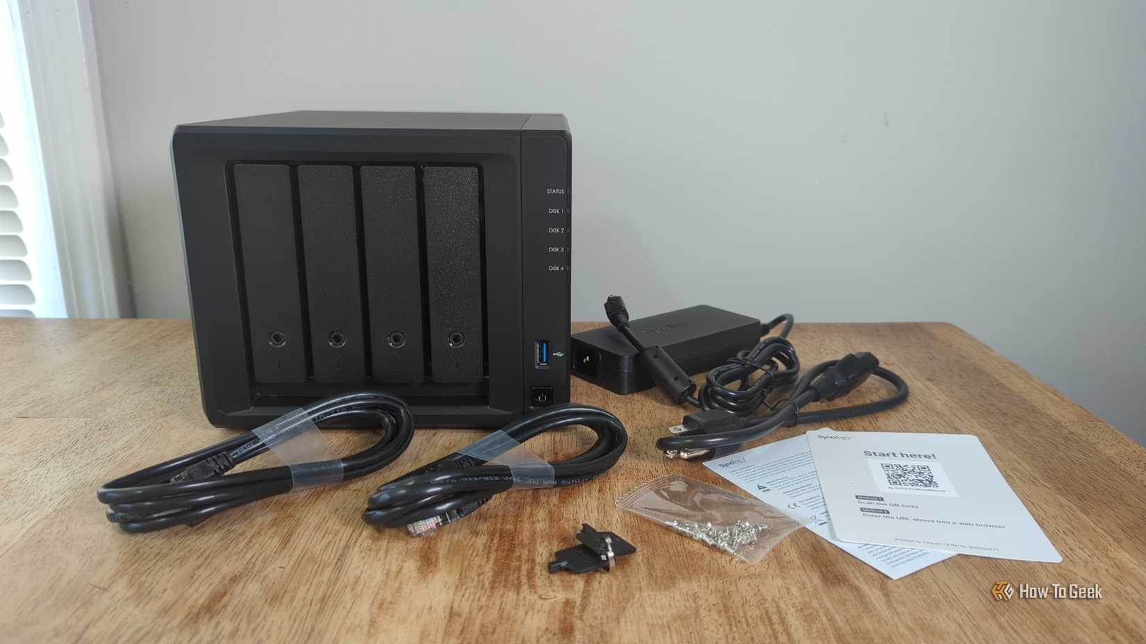 The Synology DS425+ NAS on a table with all of its accessories.-2