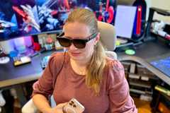 Woman wearing VITURE Luma Pro XR Glasses while holding a smartphone.