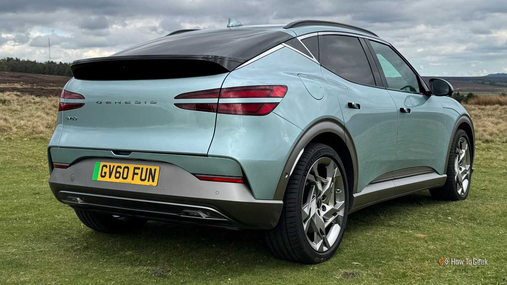 TOMA ESTÁTICA TODA 3/4 de un Aqua Blue 2025 Genesis GV60 estacionado en hierba.