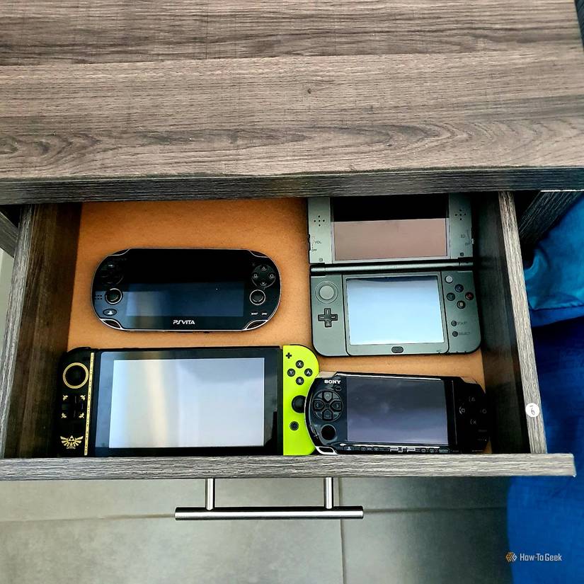 A bunch of handheld consoles in a bedside drawer.