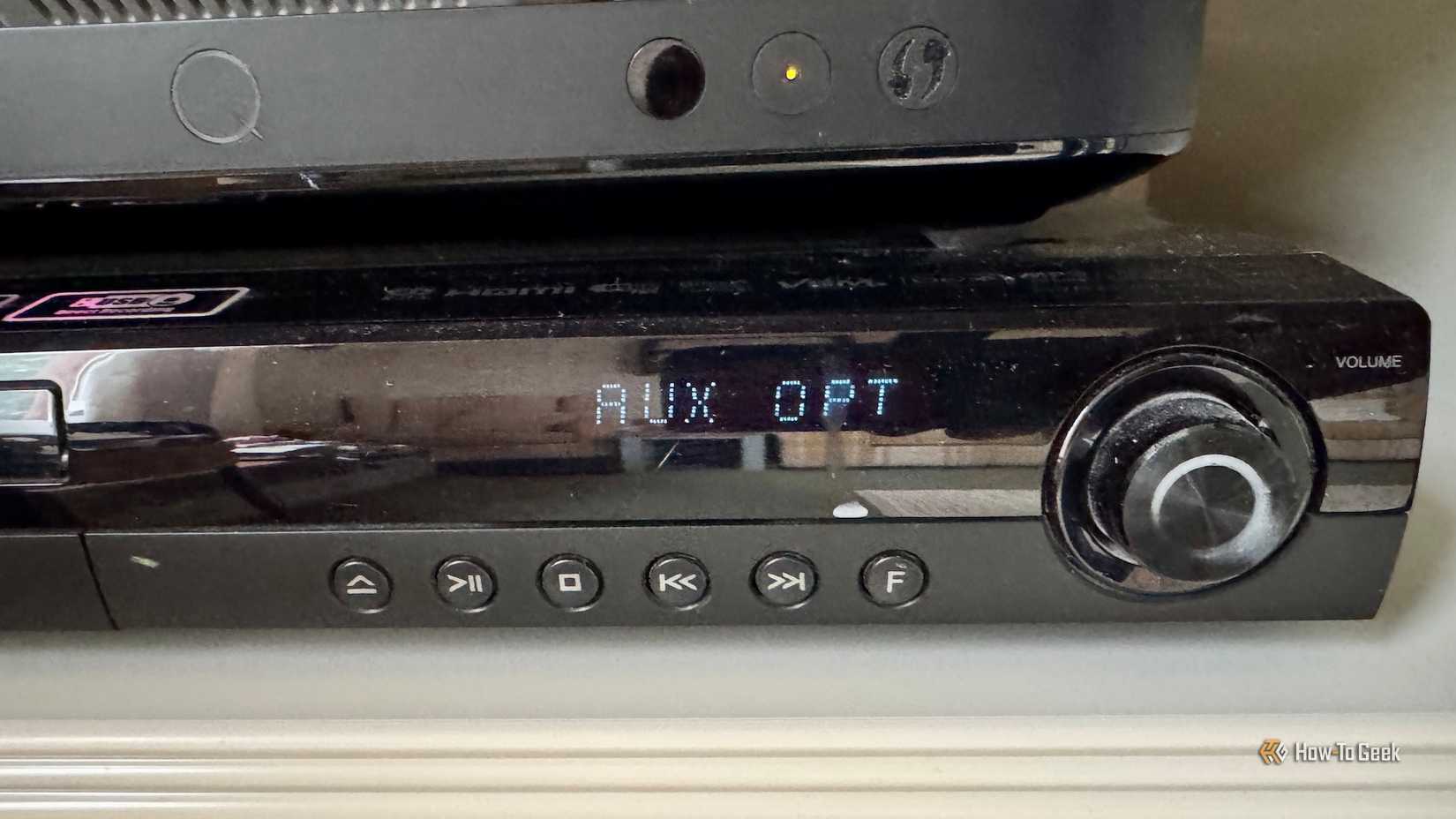 A close up of the receiver of the LG HT805PH surround sound system showing the AUX OPT option.