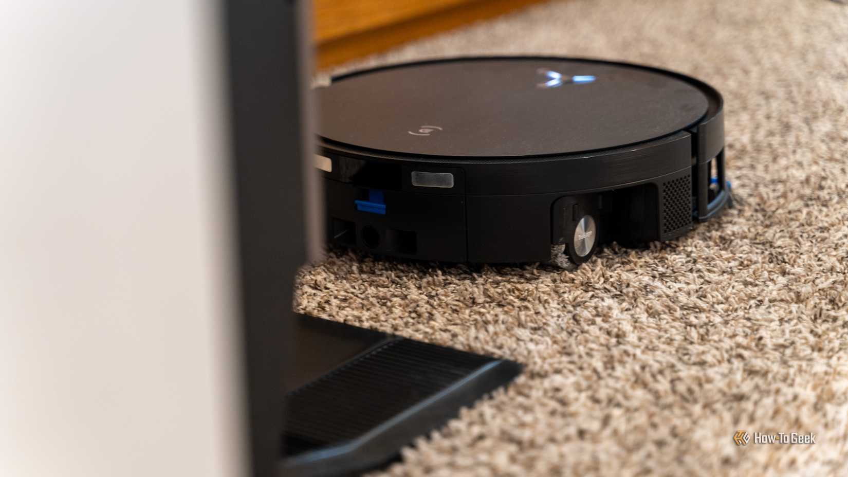 The Deebot X11 Omnicyclon backing into the charging station on carpet.