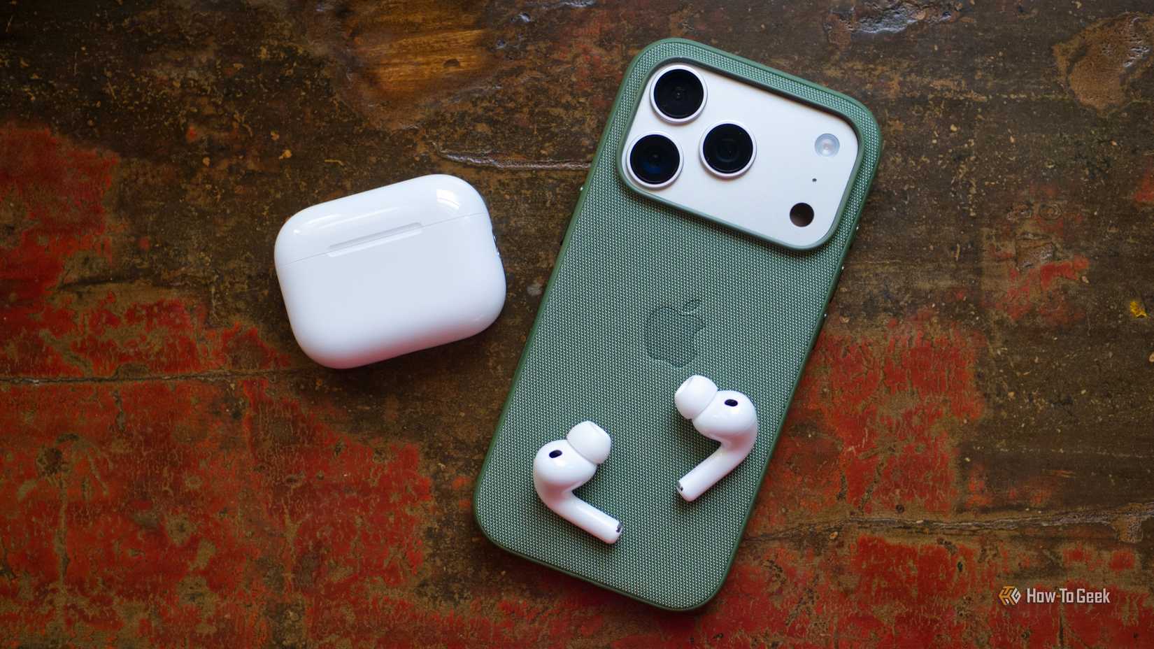 Apple AirPods Pro 3 with iPhone 17 Pro face down.