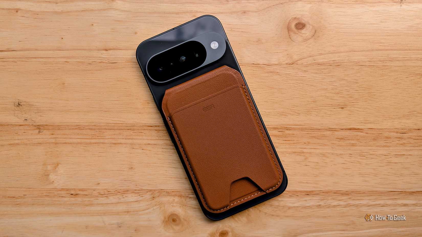 Google Pixel 10 laying on a table with a Pixelsnap magnetic wallet attached.