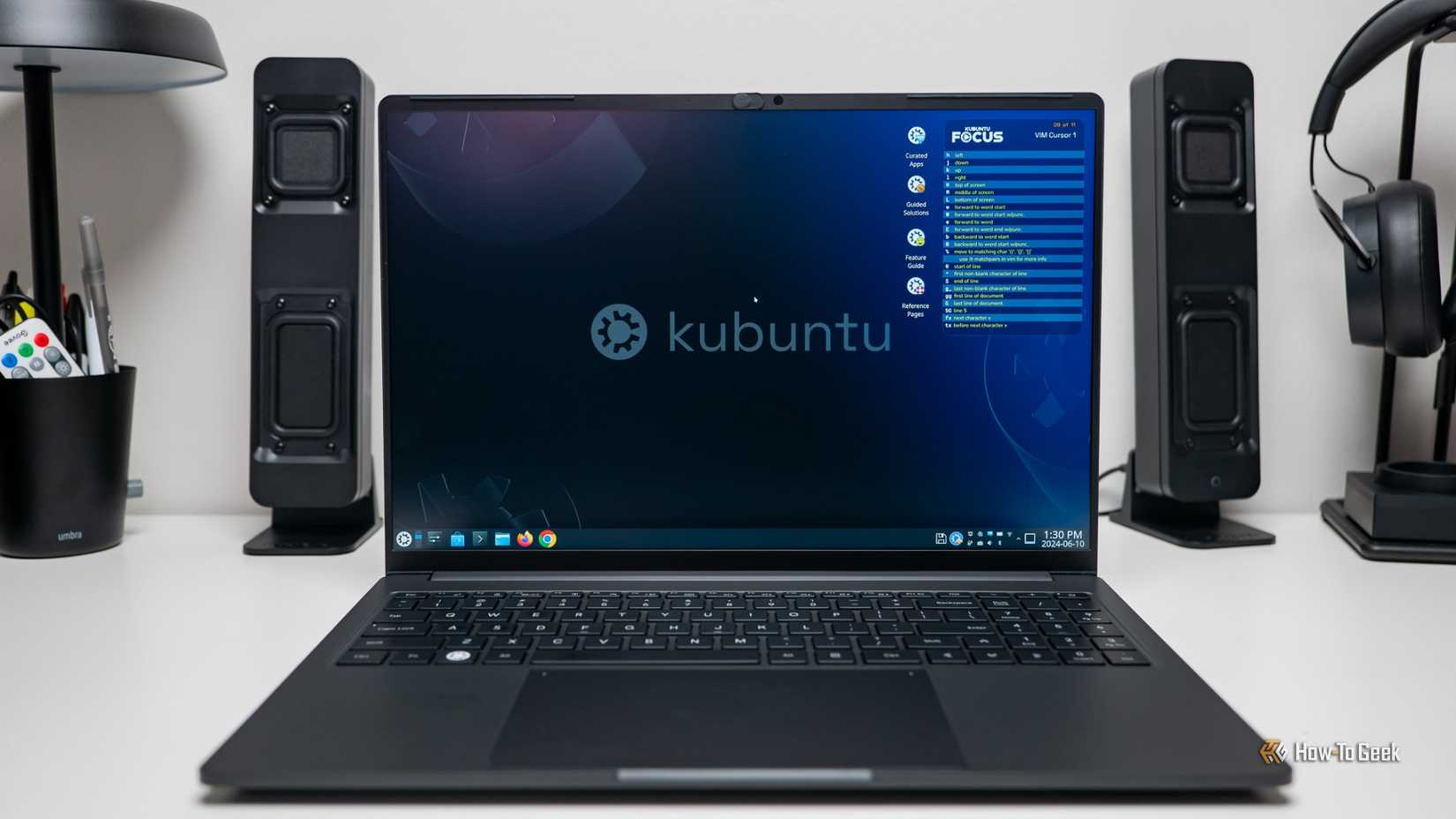 Tela inicial do laptop Kubuntu Focus IR16 (Gen 2) entre dois alto -falantes.