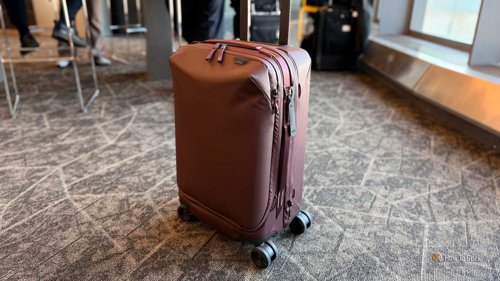 Peak Design rolling suitcase at an airport.